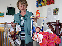 Waltraud Bock-Brce zeigt ihre selbst gestrickten Puppenhängematten und Puppenpullover (Foto Gisela Baudy)