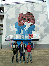 Bild 20: Künstler MILLO (Mitte) mit seinen Helfer:innen (Foto Gisela Baudy, 12.05.22)
