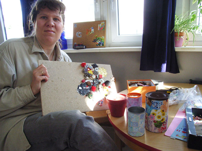 Marlies Schröder zeigt beklebte Dosen, angemalte Tontöpfe und angefangene Bildpuzzles aus Abfallstoffen (Foto Gisela Baudy)